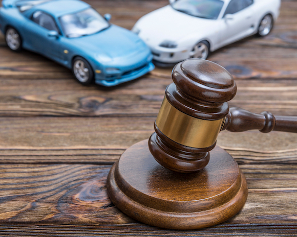 Gavel of the judge and two cars